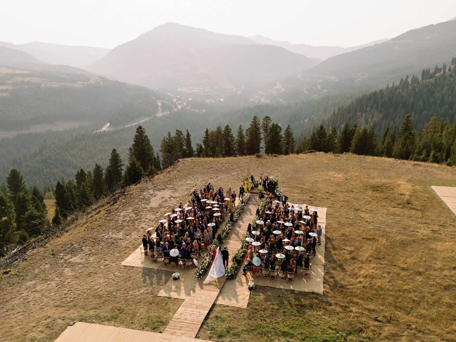 Outdoor wedding ceremony on a hilltop with a valley in the background.