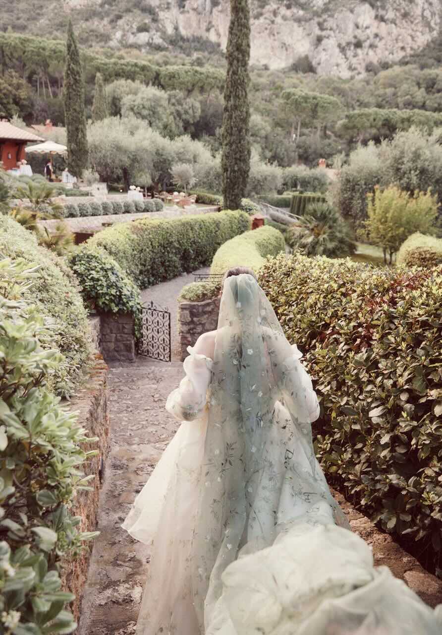 Bride speaking with seated guests at a reception.