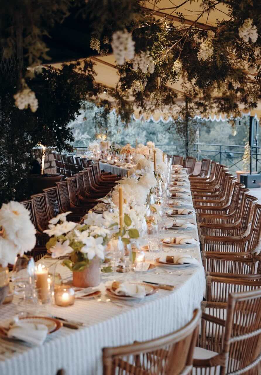 Bride speaking with seated guests at a reception.