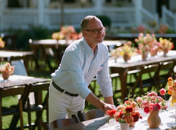 Matthew Robbins assembling floral arrangements on a table.